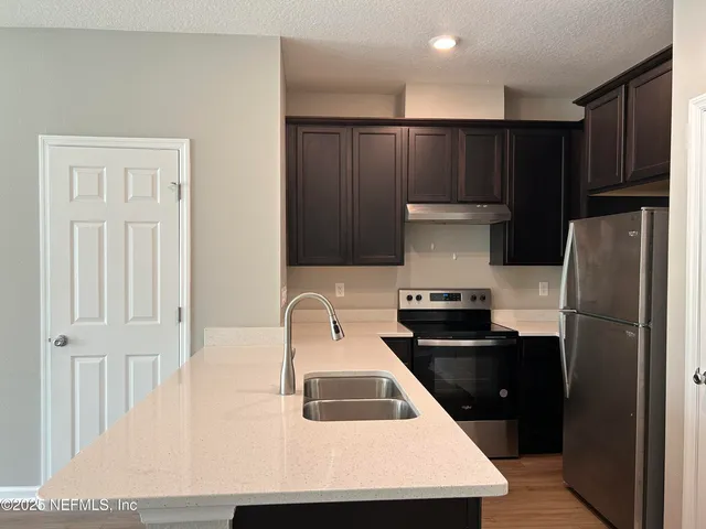 a kitchen with a refrigerator and a sink