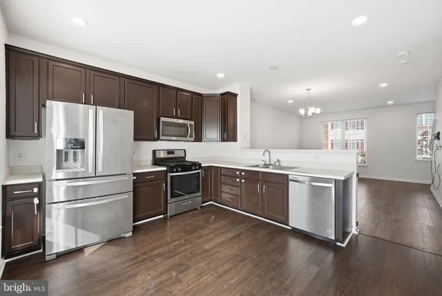 a large kitchen with a stove top oven a refrigerator and white cabinets