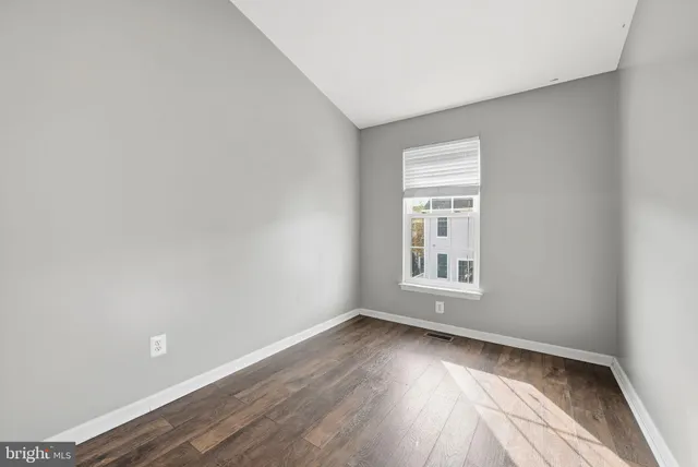 wooden floor in an empty room with a window
