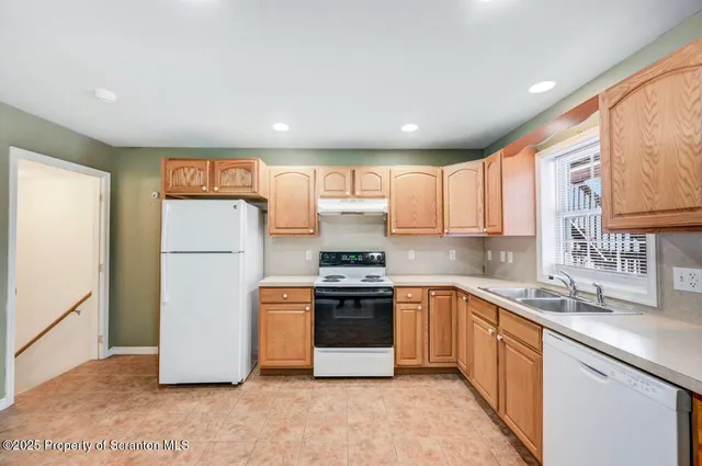 a kitchen with a sink a refrigerator and cabinets