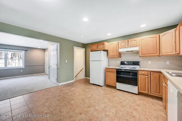 a large kitchen with stainless steel appliances granite countertop a stove and a refrigerator
