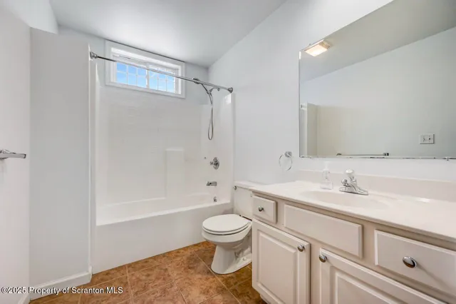 a bathroom with a sink a toilet and a large mirror