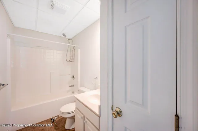 a bathroom with a granite countertop toilet a sink and a bathtub