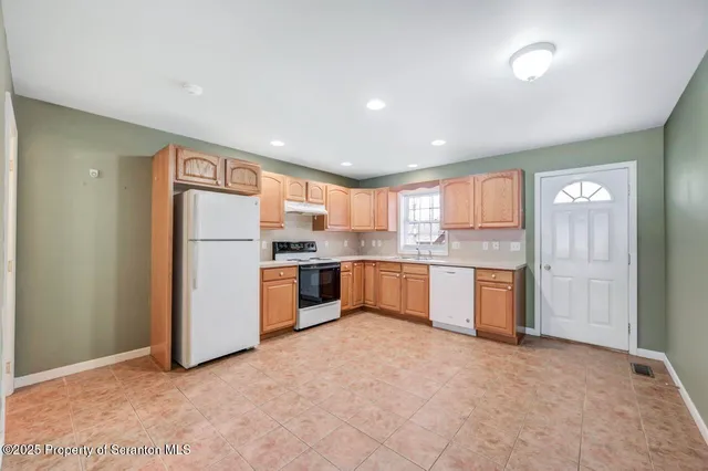 a kitchen with refrigerator and cabinets