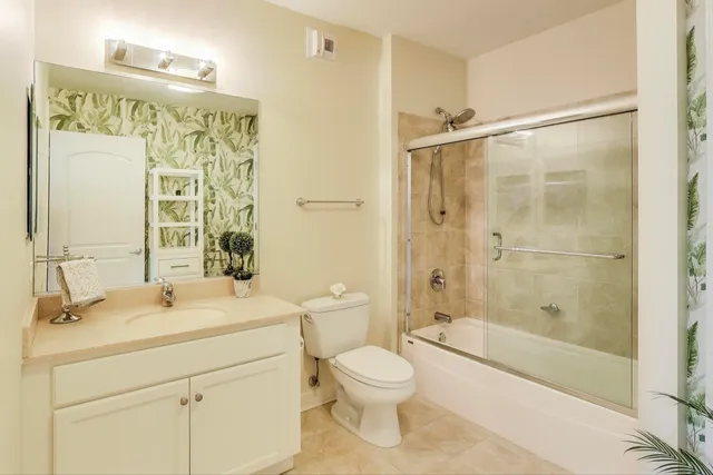 a bathroom with a shower sink vanity mirror and toilet