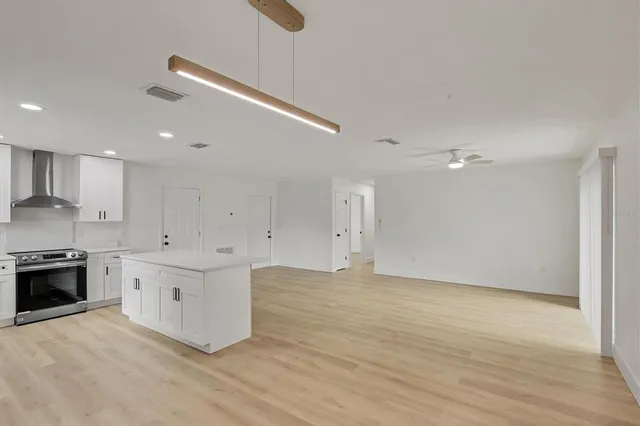 a large kitchen with cabinets wooden floor and stainless steel appliances