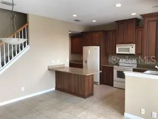 a view of an empty room with a kitchen
