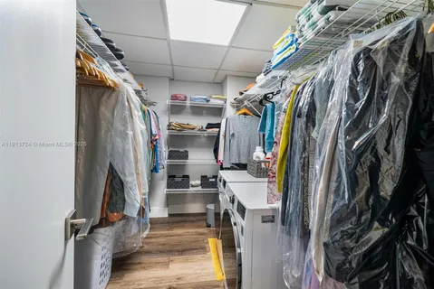 a view of walk in closet with clothes and shoes