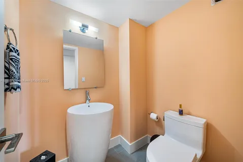 a bathroom with a toilet a sink and mirror