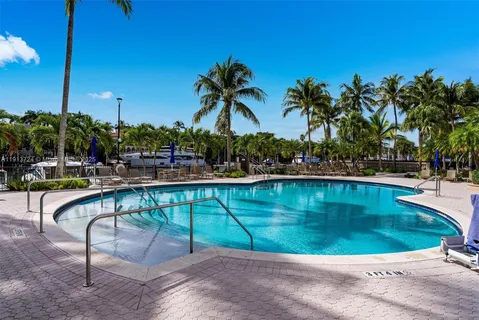 a view of swimming pool with outdoor seating and palm tree