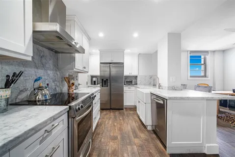 a kitchen with a sink a counter top space stainless steel appliances and cabinets