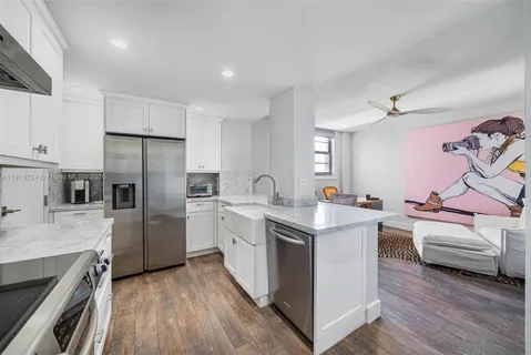 a kitchen with white cabinets and stainless steel appliances