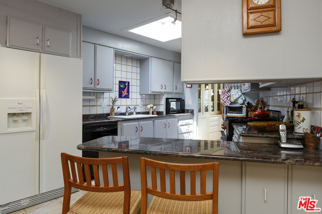 29500 Heathercliff Road, Unit 202 Malibu, CA 90265 - Photo 13 of 30 a kitchen with stainless steel appliances granite countertop a sink counter space and cabinets