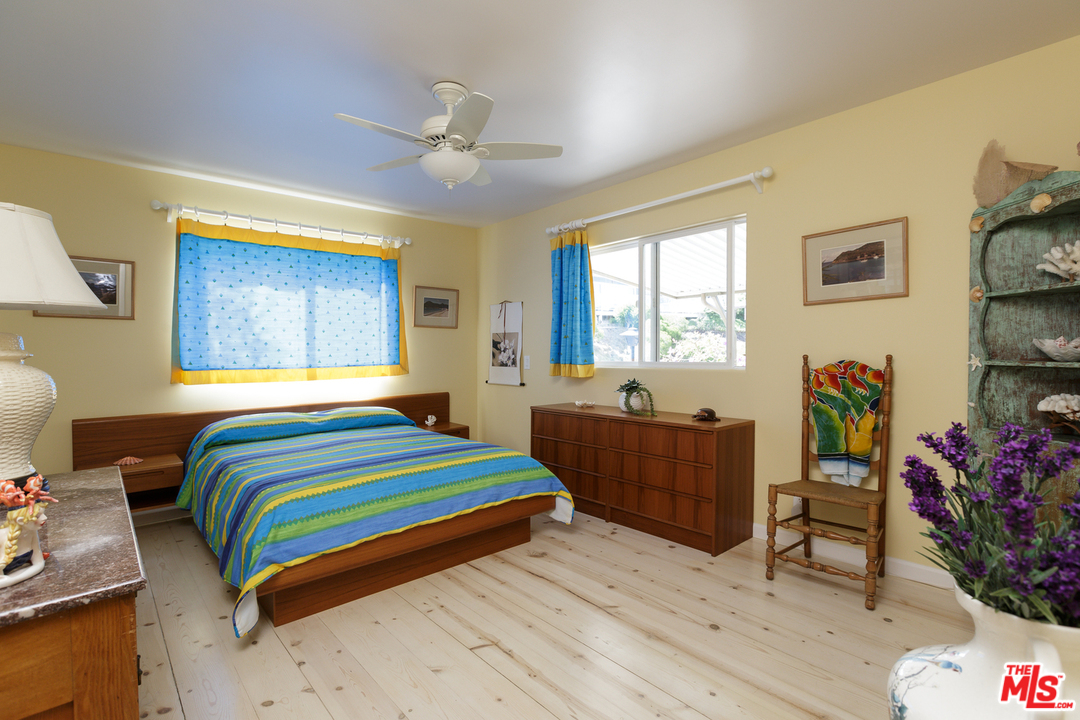 29500 Heathercliff Road, Unit 202 Malibu, CA 90265 - Photo 18 of 30 a bedroom with a bed and a dresser next to a window