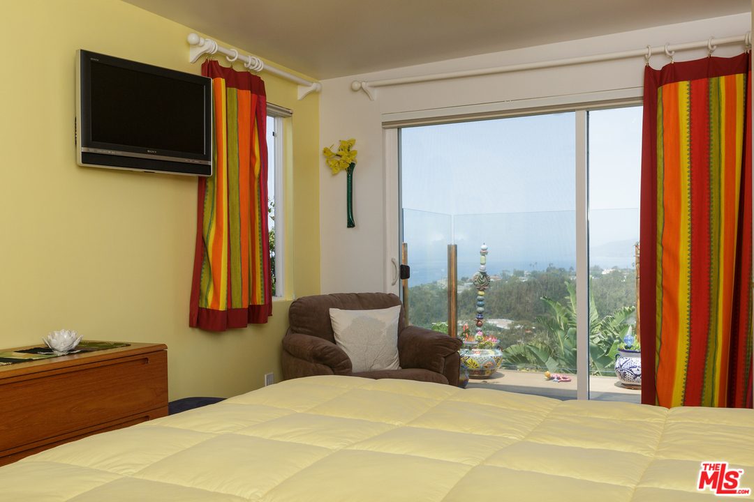 29500 Heathercliff Road, Unit 202 Malibu, CA 90265 - Photo 24 of 30 a bedroom with a bed and large windows