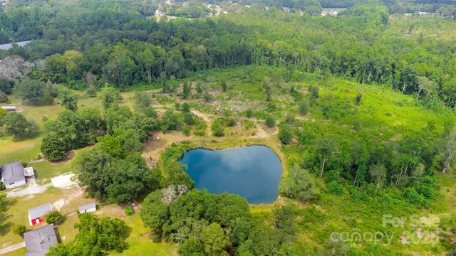 an aerial view of residential house with outdoor space and trees all around