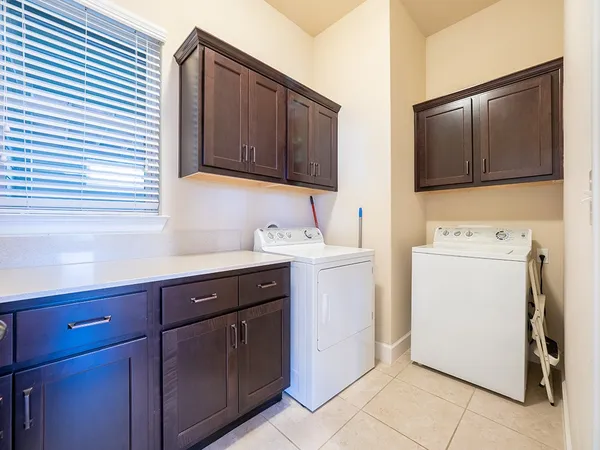 a utility room with cabinets washer and dryer