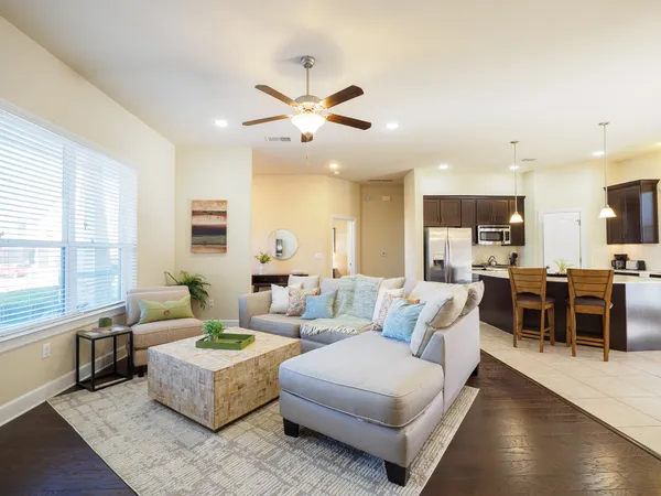 a living room with furniture kitchen view and a large window