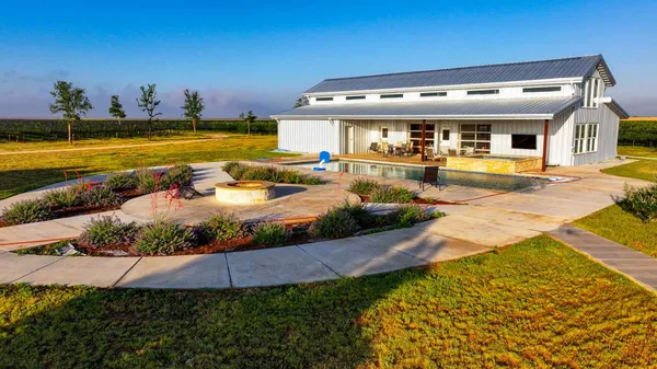 a view of a house with swimming pool and sitting area
