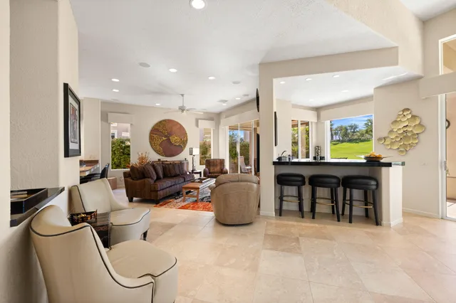 a living room with furniture a large window and a flat screen tv