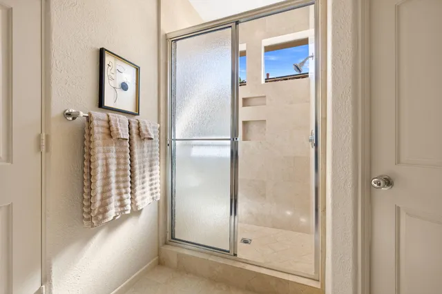 a view of a patio with lawn chairs and swimming pool