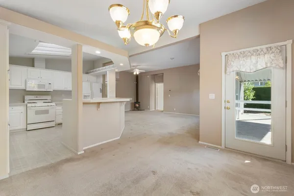 an empty room with windows and chandelier