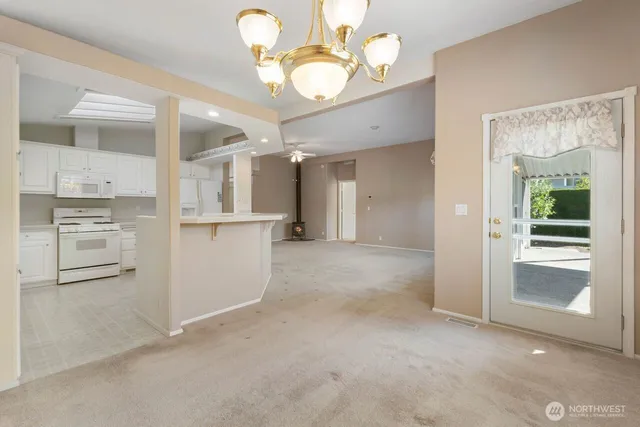 an empty room with windows and chandelier