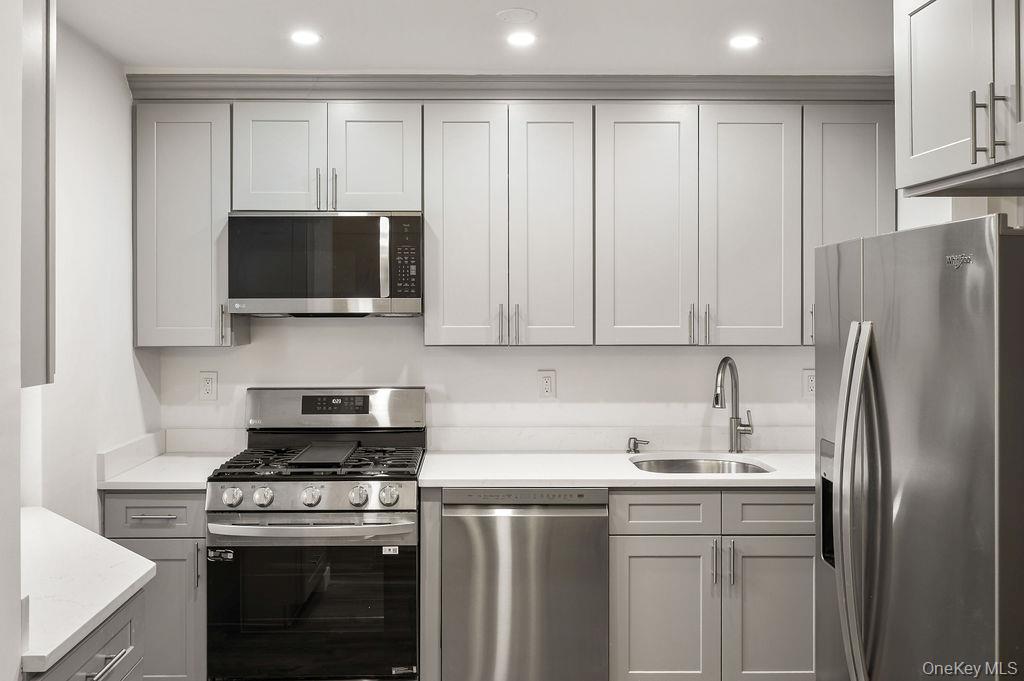 103 Wiltshire Road, Unit D6 Scarsdale, NY 10583 - Photo 8 of 20 a kitchen with stainless steel appliances a stove a sink and a microwave