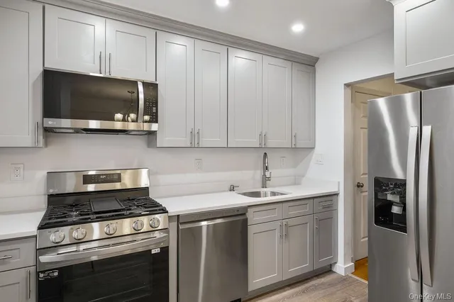 a kitchen with stainless steel appliances a stove a microwave and a sink