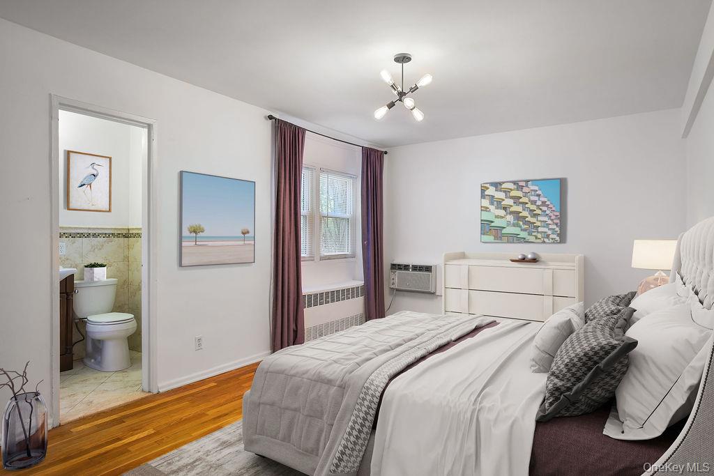 103 Wiltshire Road, Unit D6 Scarsdale, NY 10583 - Photo 10 of 20 a bedroom with a large bed and a chandelier