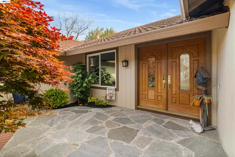 front view of a house with a large window and potted plants