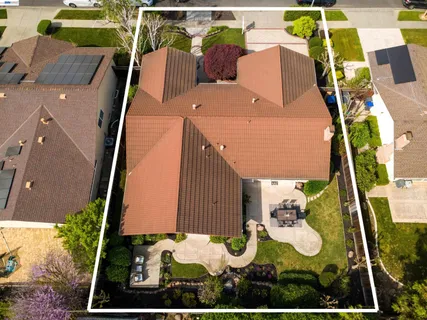 an aerial view of residential houses with outdoor space and trees