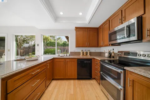 a kitchen with a refrigerator a stove a sink dishwasher with a dining table and chairs