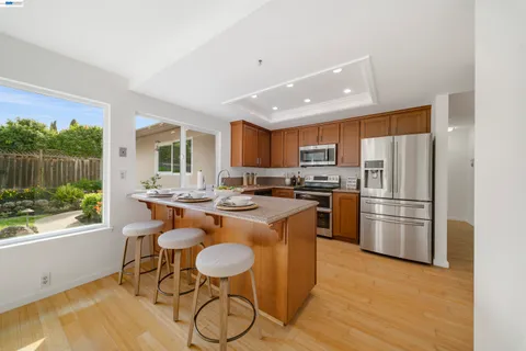 a kitchen with stainless steel appliances granite countertop a refrigerator sink and microwave