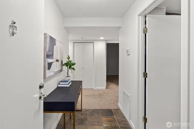 a view of a hallway with wooden floor and a potted plant