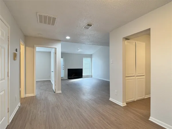 an empty room with wooden floor and fireplace