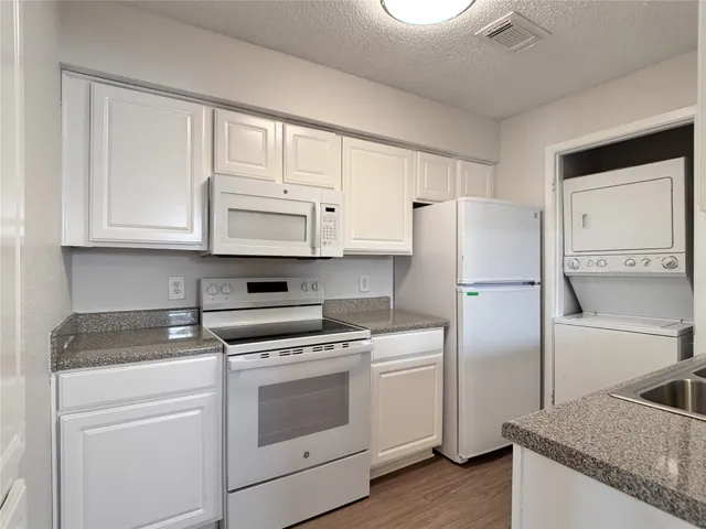 a kitchen with white cabinets and white appliances