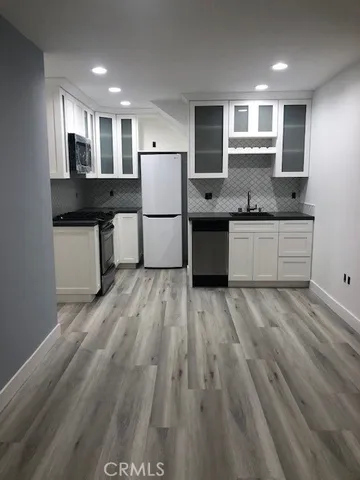 a kitchen with a refrigerator sink and wooden cabinets