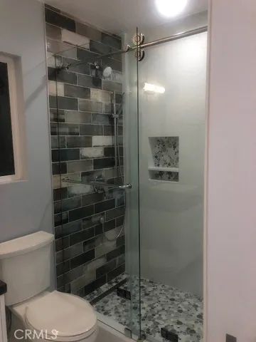 a bathroom with a toilet and a shower
