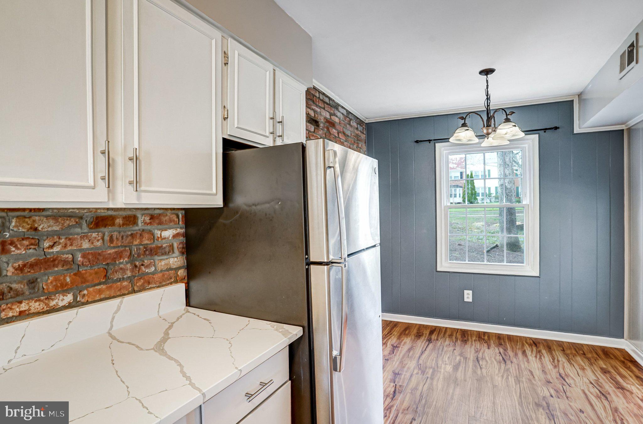 8396 Forrester Boulevard, Unit 555 Springfield, VA 22152 - Photo 5 of 24 a kitchen with granite countertop a refrigerator and a stove top oven