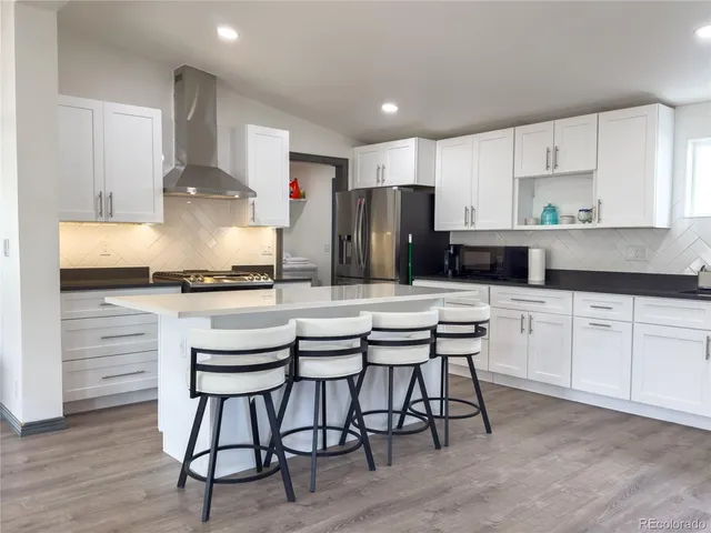 a kitchen with a table chairs refrigerator and cabinets