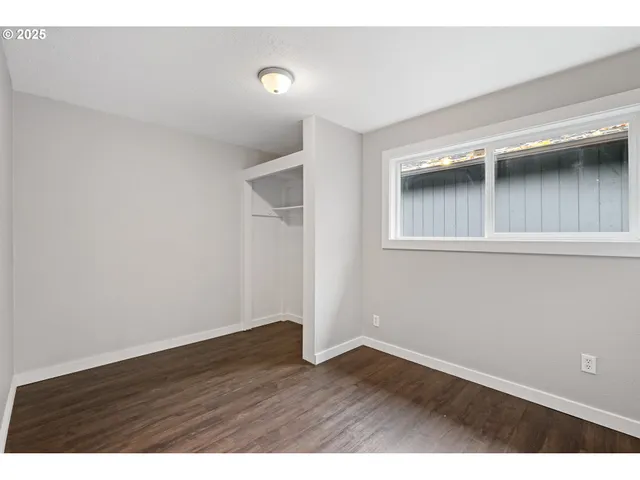 an empty room with wooden floor and cabinet