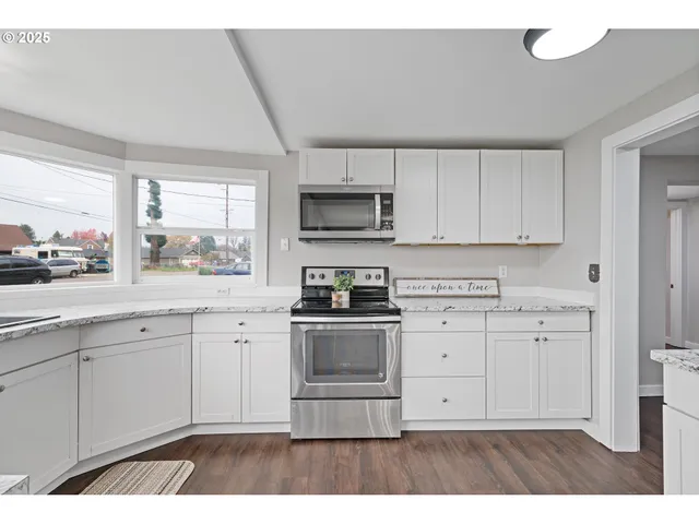 a kitchen with stainless steel appliances granite countertop a stove a sink and a microwave