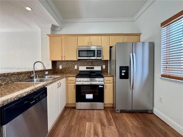 a kitchen with stainless steel appliances granite countertop a stove a sink and a microwave