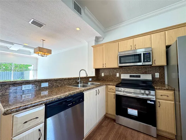 a bedroom with a bed and dresser with wooden floor