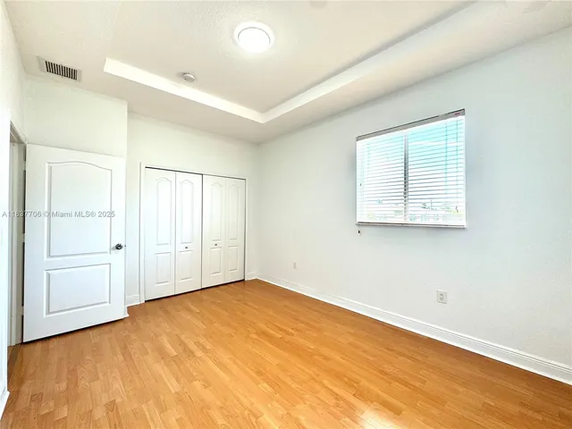 a view of a room with wooden floor and window