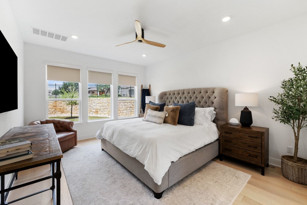 365 Pear Tree Lane Austin, TX 78737 - Photo 20 of 39 a bedroom with a large bed and a chandelier