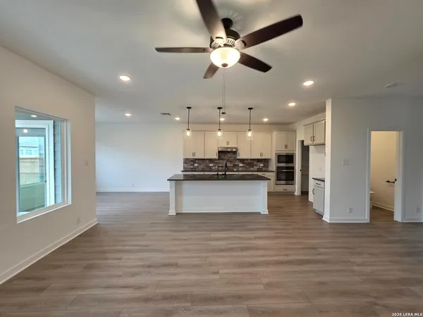 a kitchen with stainless steel appliances granite countertop a sink a stove a refrigerator and island with wooden floor