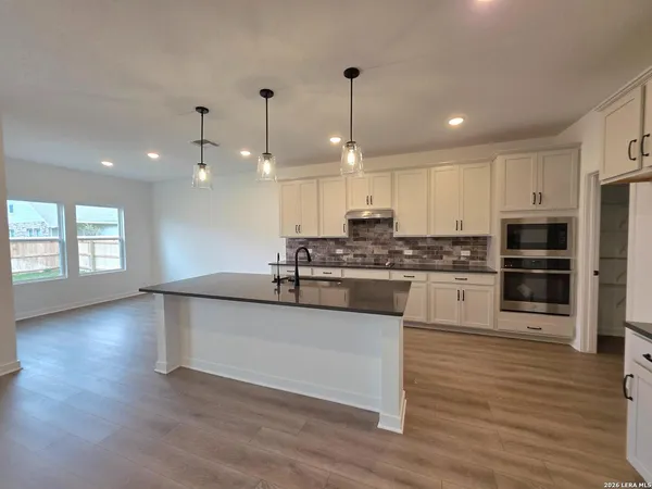 a kitchen with stainless steel appliances granite countertop a sink a stove and a refrigerator