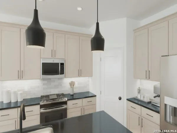 a kitchen with kitchen island a counter top space appliances and a view of living room